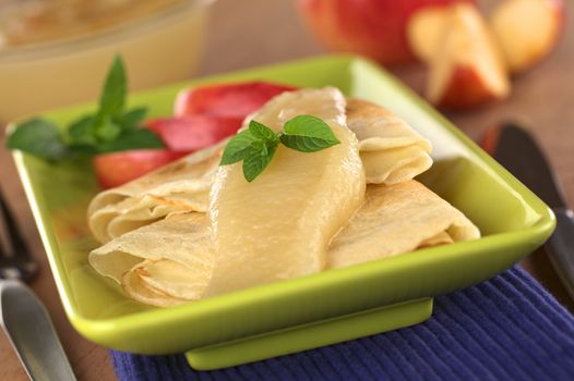 Crepes with apple sauce (Selective Focus, Focus on the mint leaf)