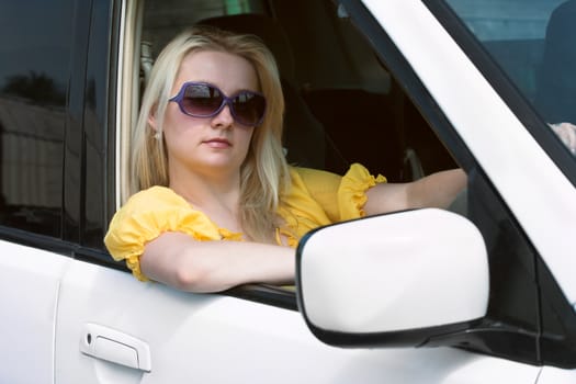 The young woman behind a rudder of the automobile

