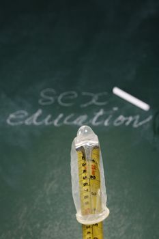 stock image of the condom in front of blackboard