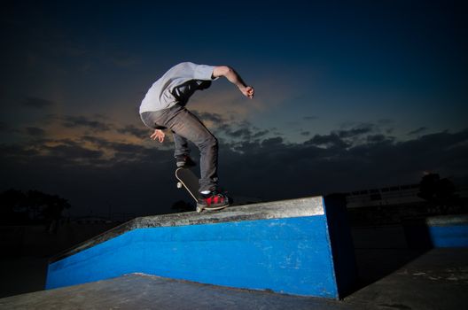 Skateboarder on a grind at the local skatepark.