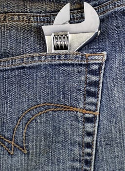 an adjustable wrench in a jeans pocket