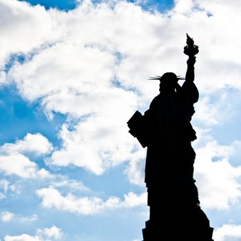 Sunnny day, blue sky with clouds: statue of Liberty with copy space