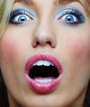 Close-up portrait of the surprised lady with good makeup screaming. Vibrant colors