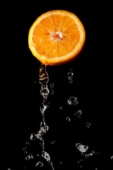Fresh and bright orange part and waterdrops flying