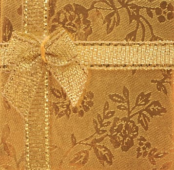 gold ribbon bow on shiny golden background. greeting card. 