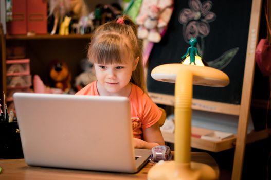 In small room young girl looking in her laptop and smiling