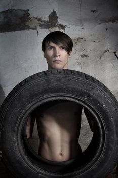 Man holding automobile tire. Horizontal photo