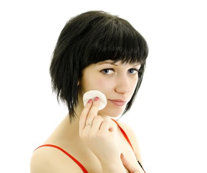 Close-up portrait of woman with cotton swab cleaning her face. Isolated on white.