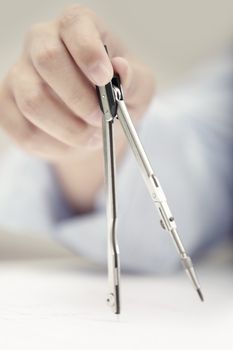 Hand of engineer working with compasses