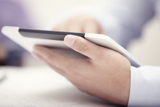 Hands of businessman using tablet PC at office