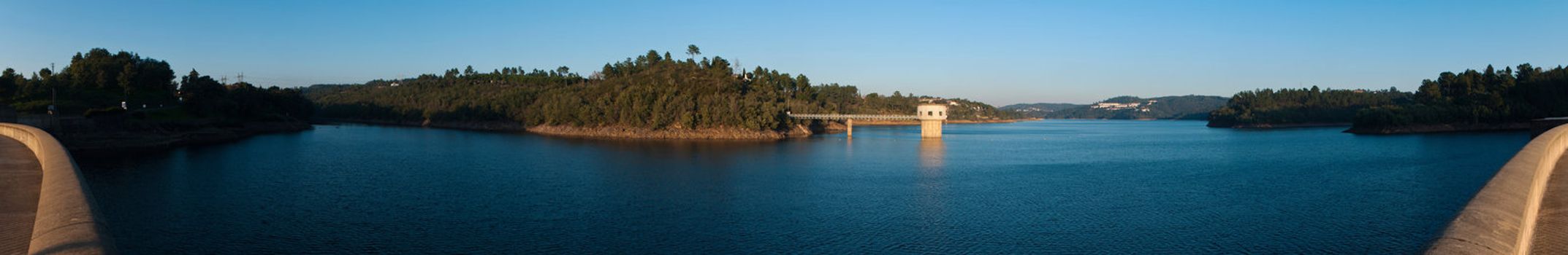 stunning view of river Zezere and Castelo de Bode Dam in Tomar, Portugal (panoramic picture with gorgeous blue sky)