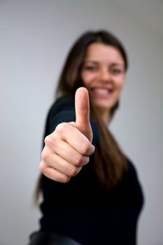 Dark haired girl with thumb up smiling