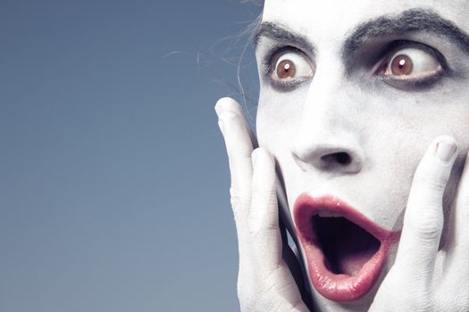 Man with white makeup expressing shock
