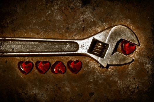 Five grunge hearts with wrench on rusty background