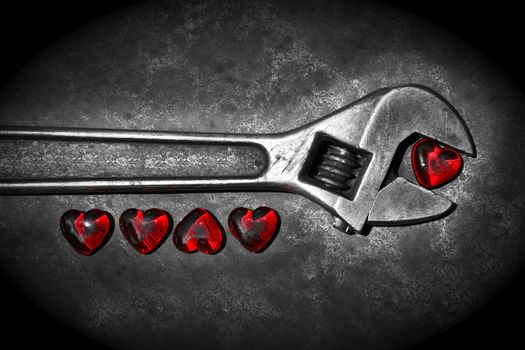 Five grunge hearts with wrench on rusty background/ BW