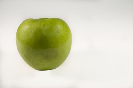 ripe green apple taken over a white background
