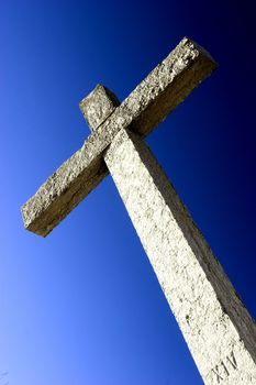 Religious stone cross on a beautiful blue sky