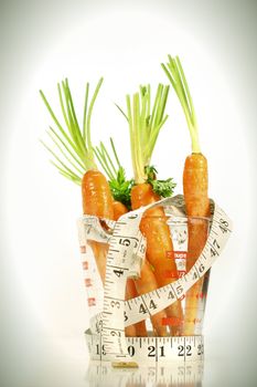 Carrots with water drops and a measuring tape wrapped around container