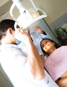 dentist and his assistant examining the patient's teeth in the office