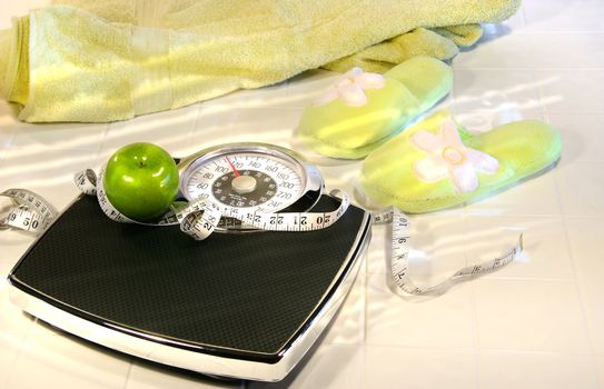 Weight scale on tile floor with towel and slippers/ Conceptual image for diet and excerise