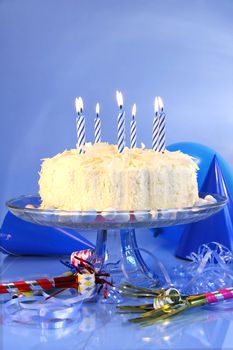 Birthday cake  with blue candles and assorted ribbons