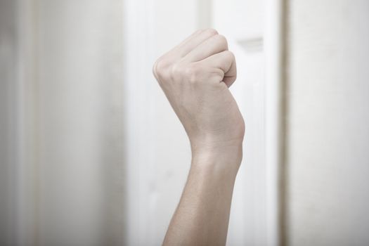 Human hand knocking at the wooden door