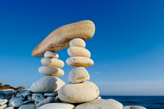 Long horizontal stone between a piles of pebble