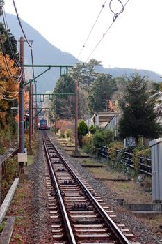 A railway in japanese mouintains with red train
