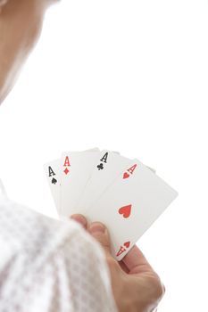 Man holding cards with Four of Aces. Rear view on a white background. Focus is on cards