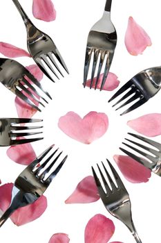 forks surrounding a heart shape petal with rose petals for a concept on romantic dining on white background with clipping path