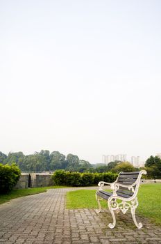 Empty bench in a park, to convey a feeling of waiting or expecting for the future or time passing.
