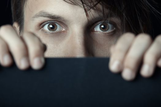 Man behind the black board looking with interest