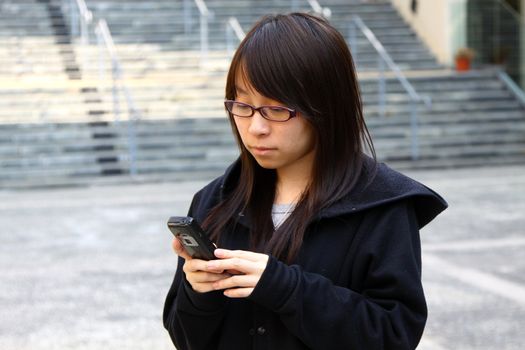 Asian woman texting message by phone