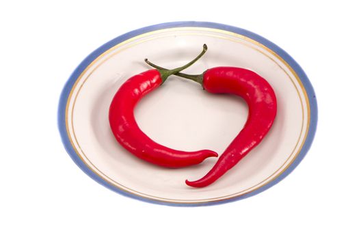 Two red hot chili pepper in dish. Healthy natural nutrition.