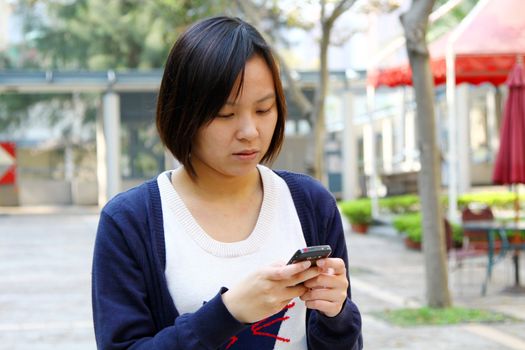 Asian woman texting message by phone