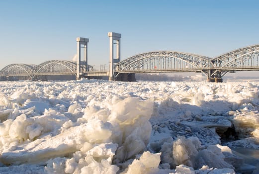 Bridge over the frozen river in sunny day