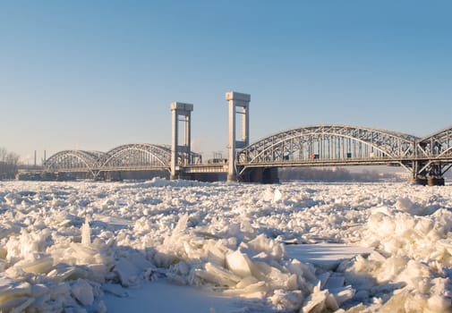Railway bridge on the frozen river in sunny day