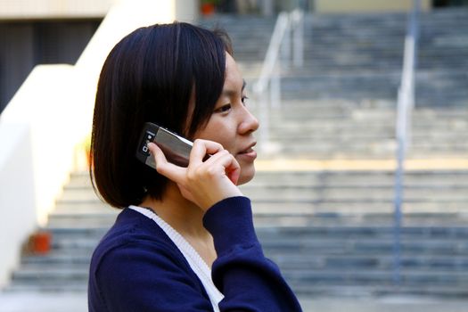 Asian woman using mobile phone and talking