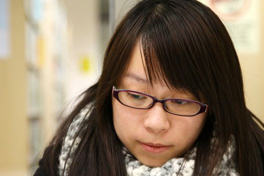 Asian woman thinking and studying in library