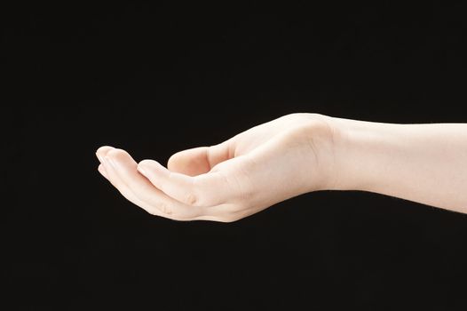 Childs hand with palm facing up - black background