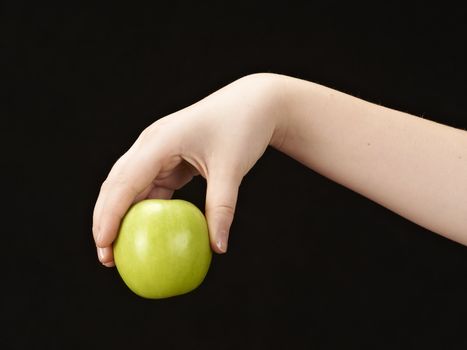 Childs hand with apple - on black background