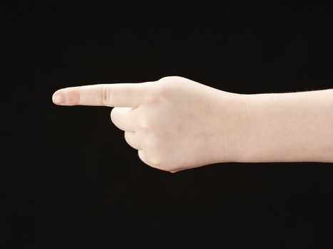 Childs hand with index finger pointing - on black background