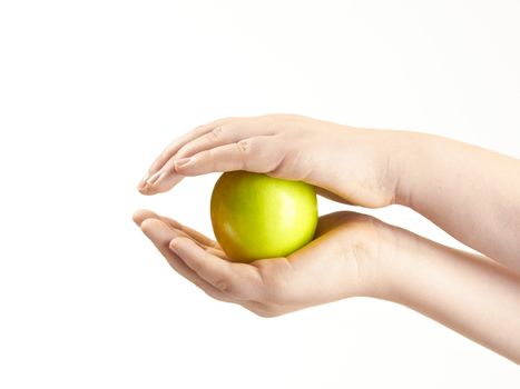 Apple sandwiched between childs hands - on white background