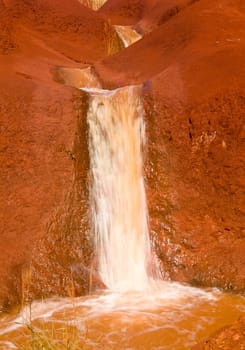 Red sandstone rocks in Waimea Canyon on Kauai with series of cascading pools