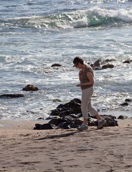 Woman beachcombing on Glass Beach in Kauai