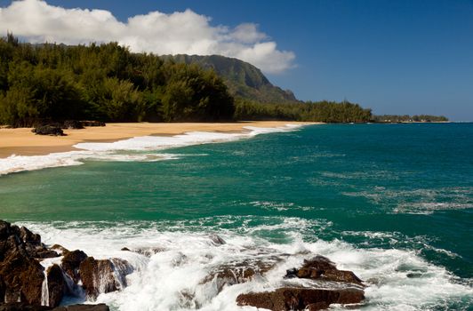 Waves crash onto Lumahai beach on Kauai Hawaii with Na Pali Coast