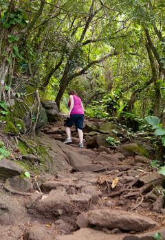 Single woman walker on Kalalau trail along Na Pali coast in Kauai Hawaii