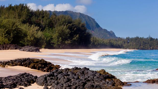 Waves crash onto Lumahai beach on Kauai Hawaii with Na Pali Coast