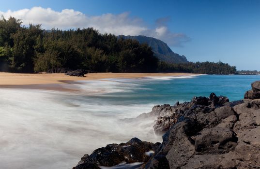 Waves crash onto Lumahai beach on Kauai Hawaii with Na Pali Coast