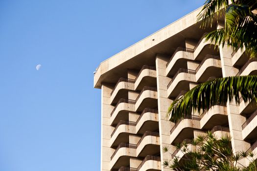 Exterior of modern hotel or apartment block with verandahs and moon in sky